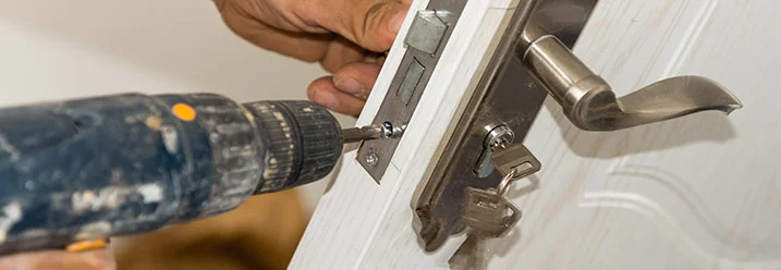 Person befestigt Türklinke mit Akkuschrauber